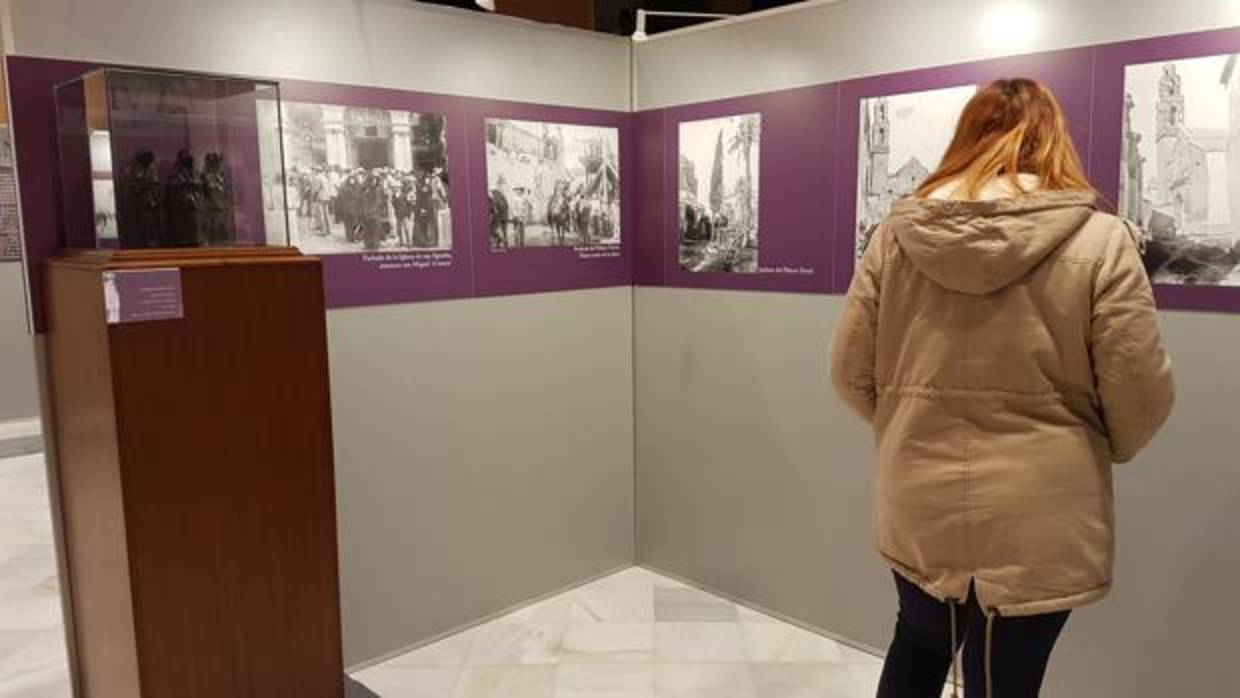 Una visitante observa la galería de fotografías de la exposición
