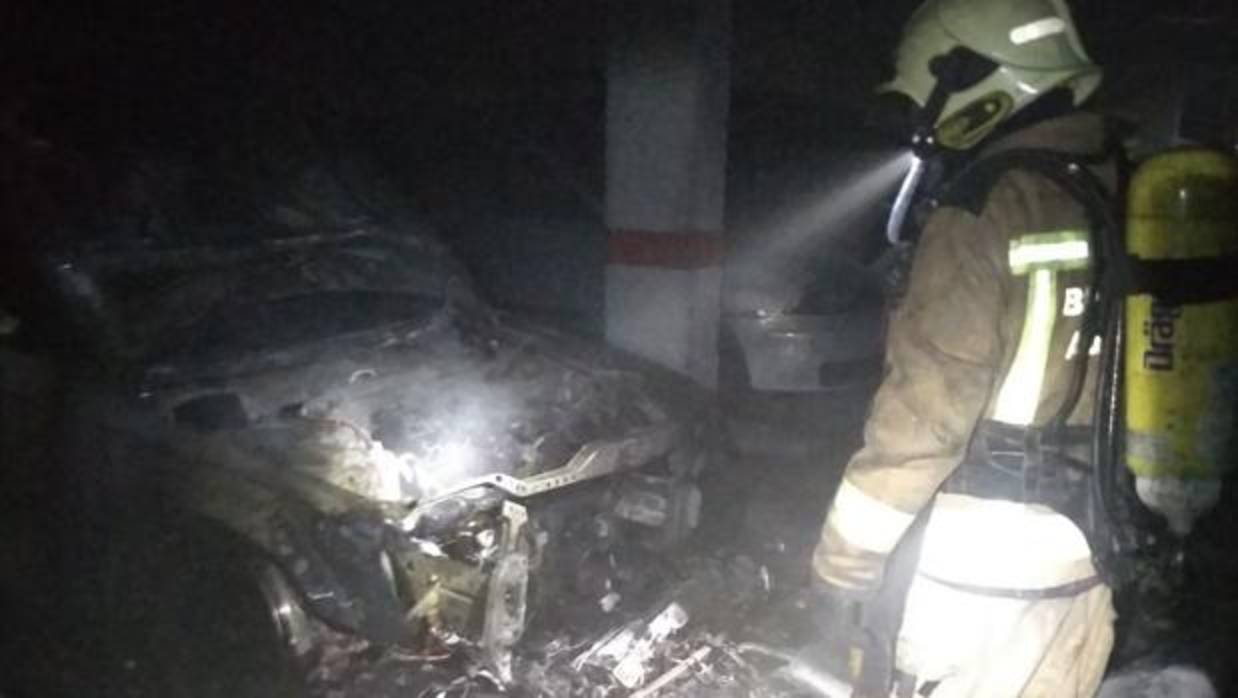 Un bombero del parque de Santiponce en el interior del garaje tras apagar el incendio del coche