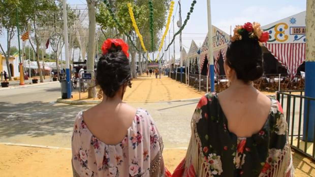 Dos gitanas pasean por una de las calles del recinto de Las Banderas que espera que el puente se convierta en el gran revulsivo de la celebración