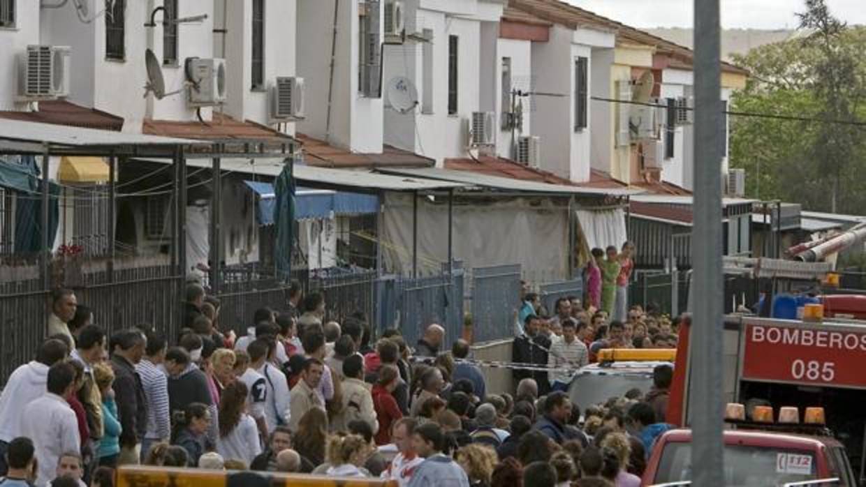 Vecinos de la familia fallecida en el incendio de Écija esperan a que los bomberos saquen los cuerpos de la vivienda