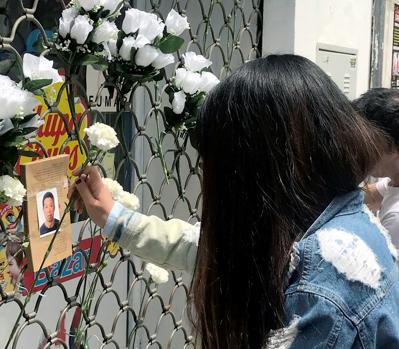 Flores en la reja del comercio del chino asesinado