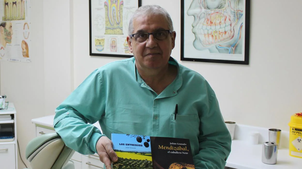 Julián Granado, en su consulta de Morón de la Frontera junto con dos de sus libros ya editados