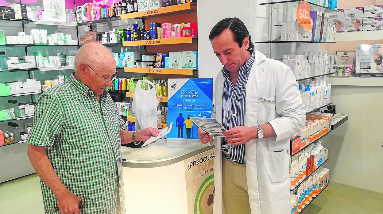 El impulsor de esta idea, Felipe Mozo, atendiendo a una persona mayor en la farmacia San Francisco de Cádiz