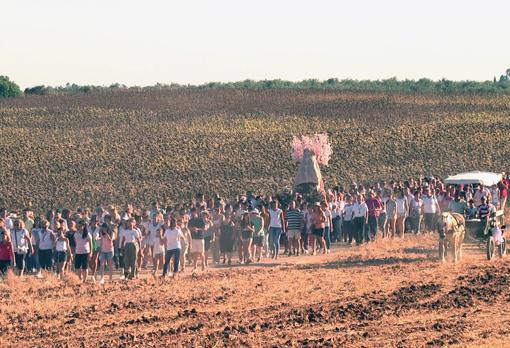 Pese a las altas temperaturas centenares de personas acompañan a la Virgen en su camino