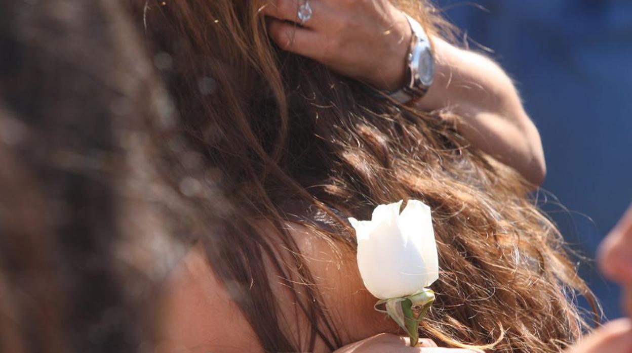 Una asistente al entierro de Sara Ojeda, fallecida en la deflagración del transformador situado en el ‘100% Fun’, porta una rosa.