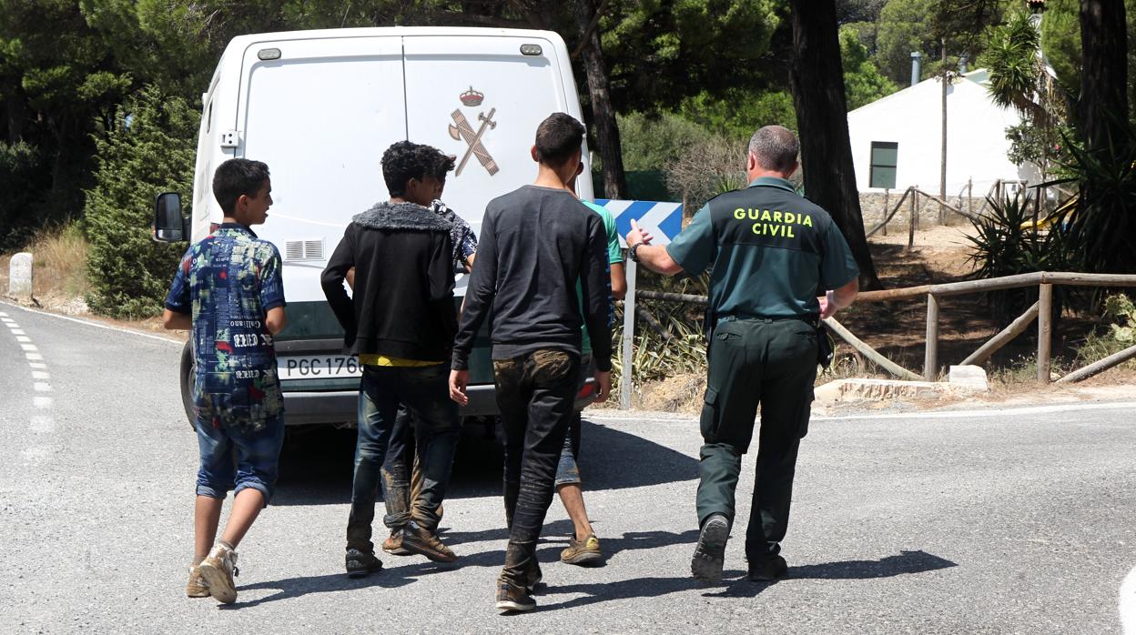 Un guardia civil acompaña a un grupo de menores extranjeros que se había escapado en Barbate