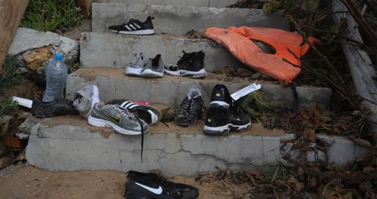 Zapatillas, chaleco y enseres, tirados en la escalera de la playa de la jaima, abandonados por los ocupantes de la patera.