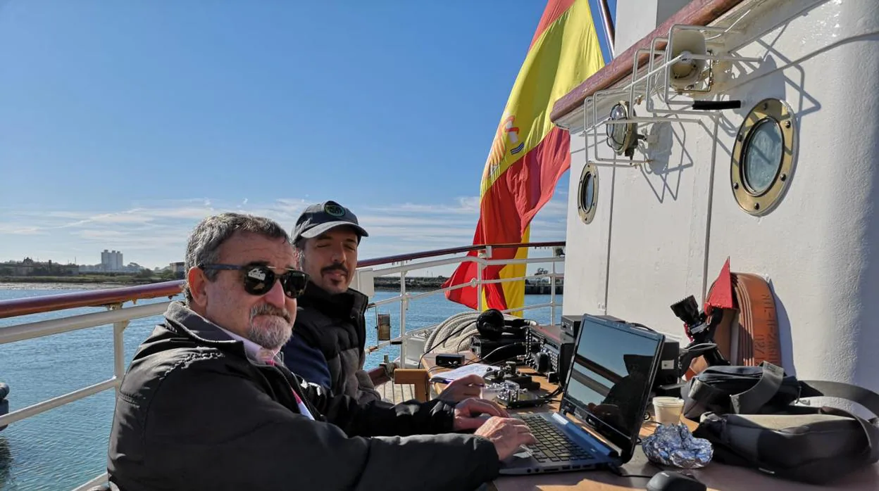 Dos radioaficionados transmitiendo con la emisora instalada a popa del Elcano.