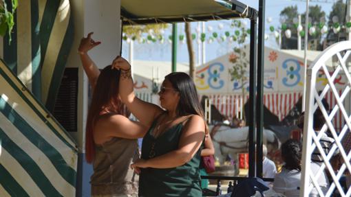 Dos mujeres bailan sevillanas.