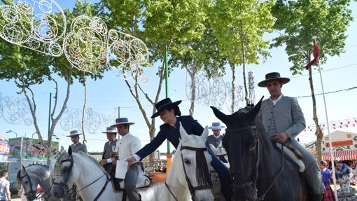 Unas personas a caballo con sus copas de vino fino.