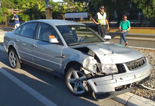 Imagen del coche ya accidentado y el conductor, detrás, de verde.