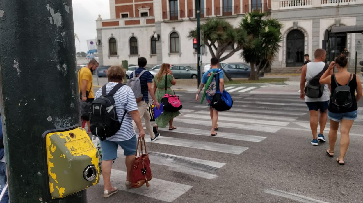 Peatones cruzando el paso de cebra con el semáforo en rojo