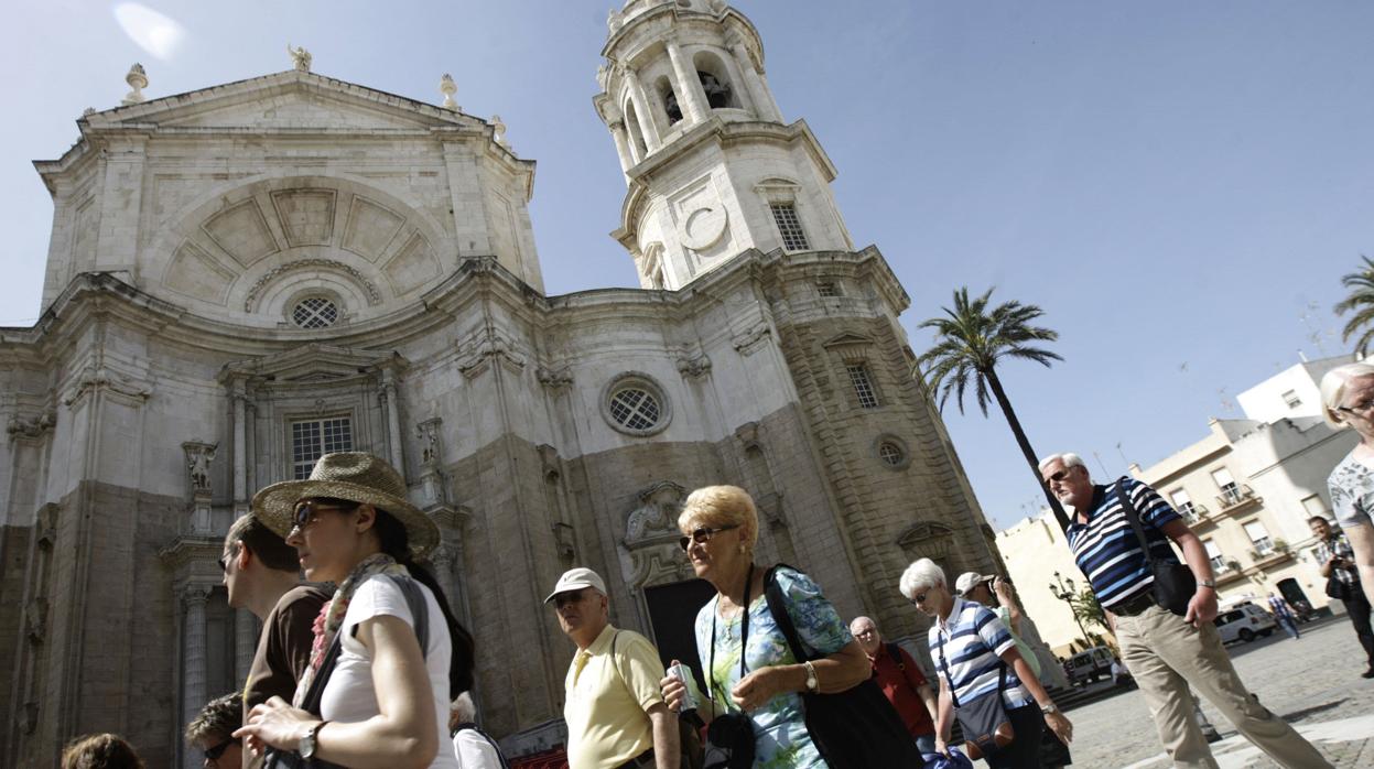 Un grupo de turistas paseando junto a la catedral.