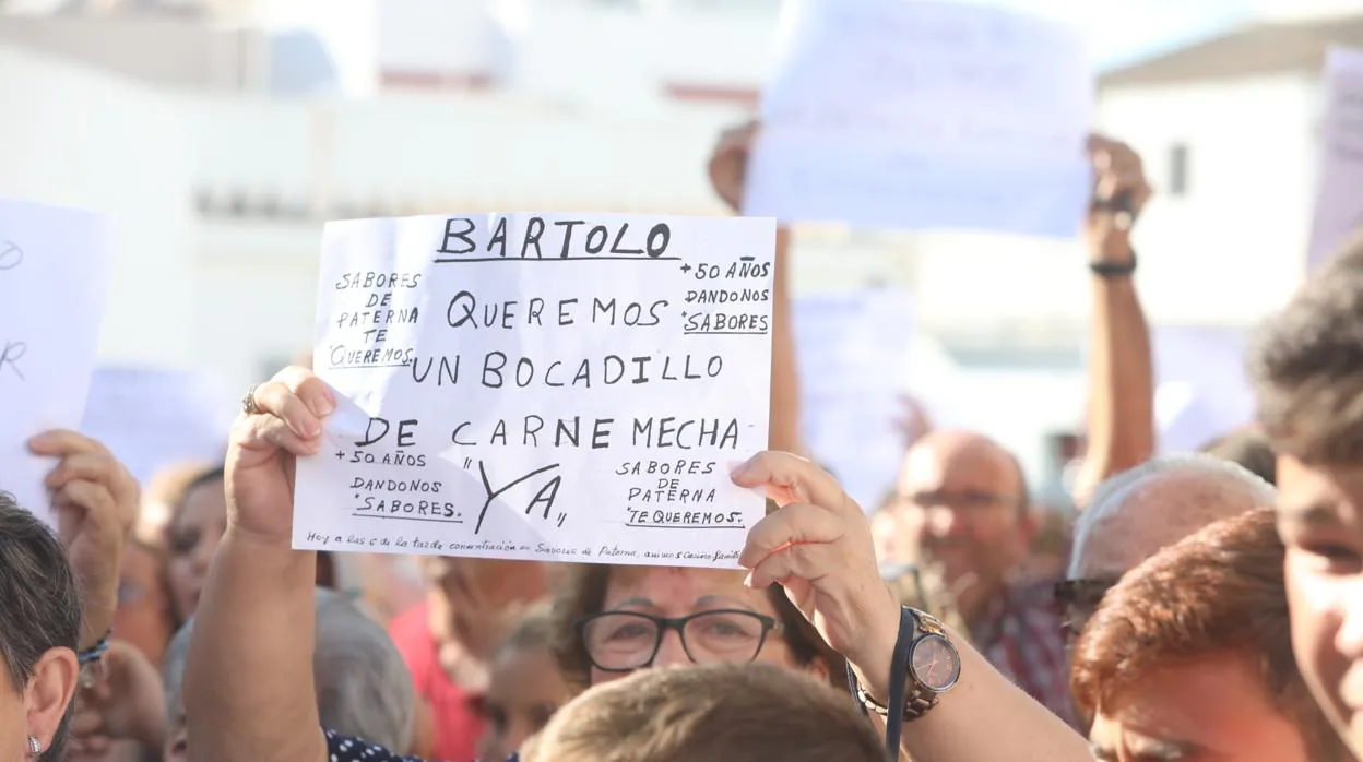 Una mujer muestra su pancarta durante la manifestación de apoyo a Sabores de Paterna.