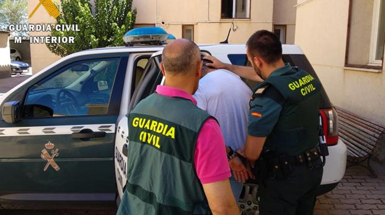 Dos agentes de la Guardia Civil introducen a un detenido en el interior de un vehículo en una operación reciente