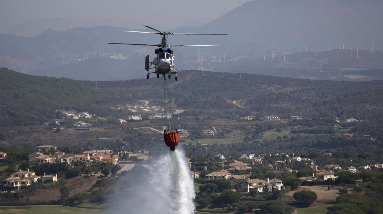Un helicóptero del Plan Infoca para la prevención y extinción de incendios de la Junta de Andalucía refresca la zona de la Sierra del Arca de San Roque.
