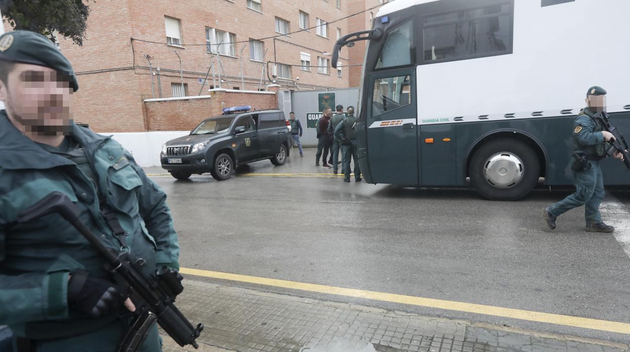 Los agentes trasladan a un detenido ante fuertes medidas de seguridad.