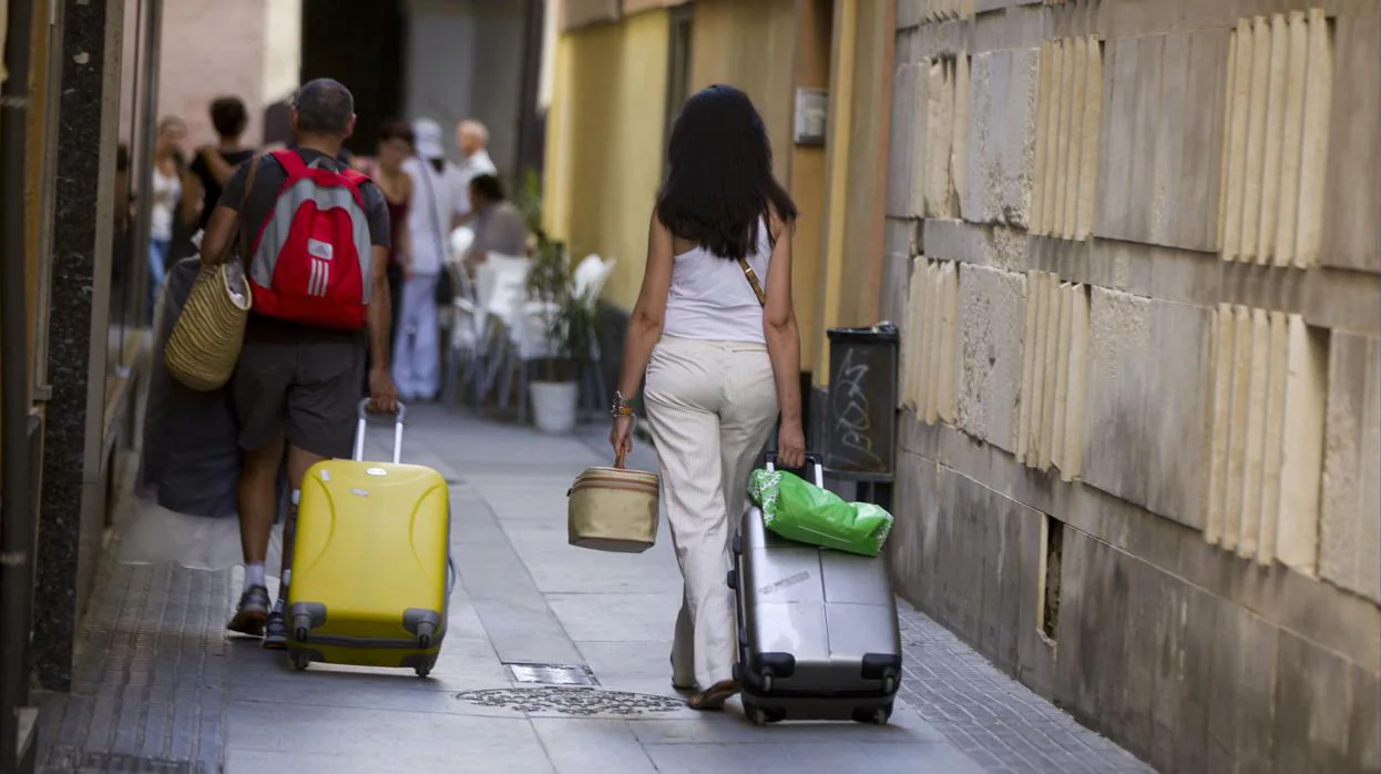 Varios viajeros se desp,lazan en busca de su alojamiento en el centro de Cádiz