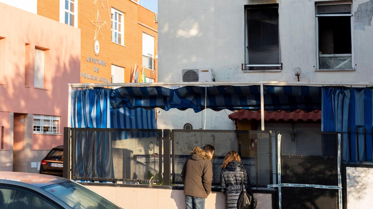 Dos personas ante la vivienda siniestrada