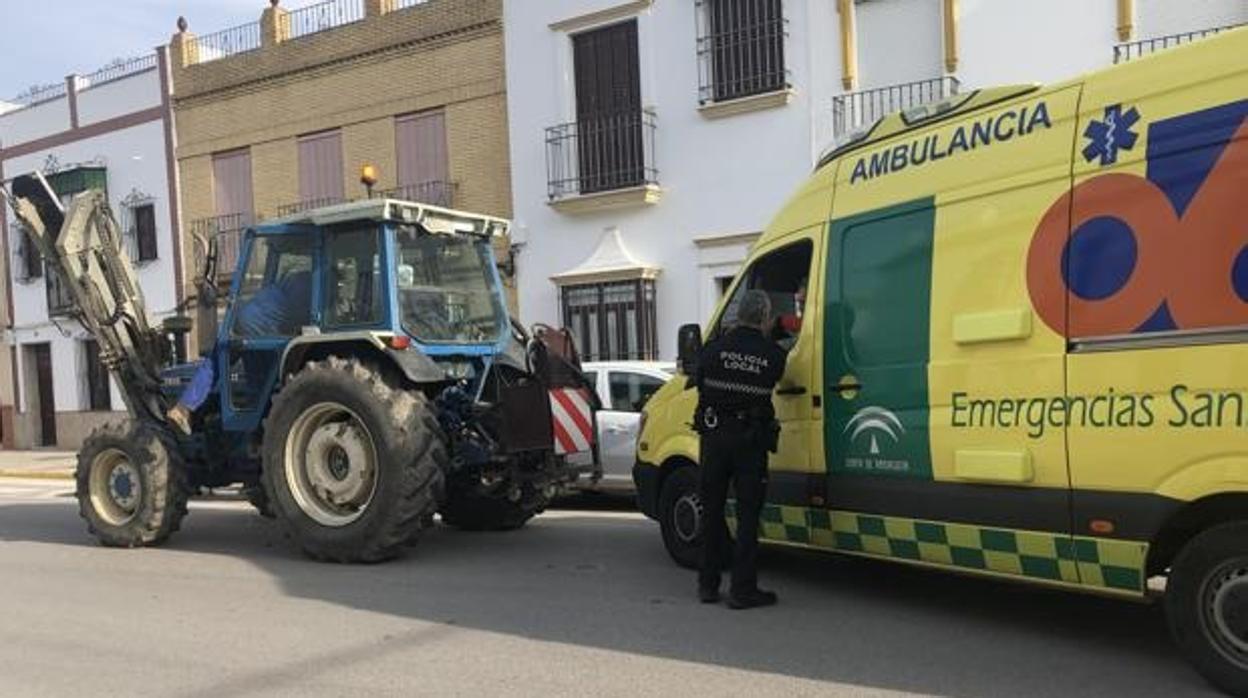 El tractor que atropelló al anciano, parado en la carretera junto a la ambulancia que lo atendía