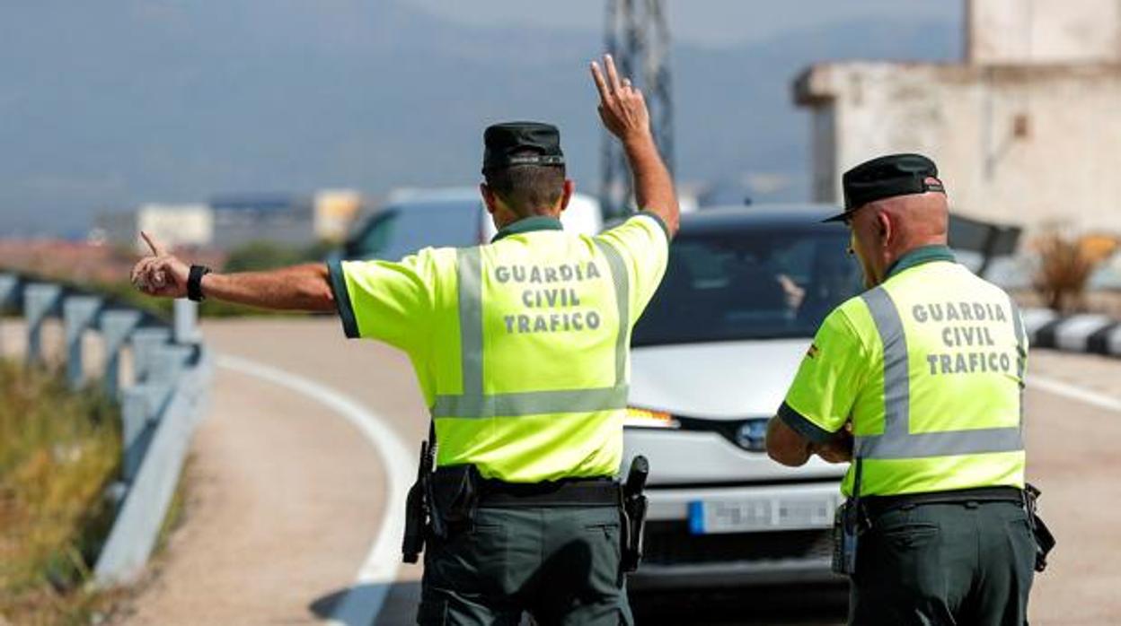 Dos agentes de la Guardia Civil de Tráfico detienen a un vehículo, en una imagen de archivo