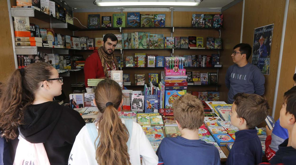 Varios escolares de Mairena del Aljarafe en un expositor durante una edición pasada de la Feria del Libro