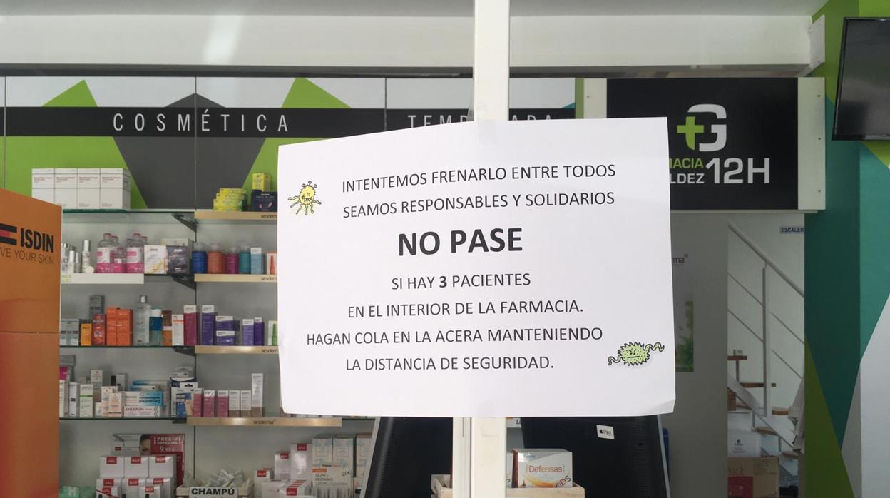 Una farmacia de El Puerto, muestra un cartel con información sobre la atención al público