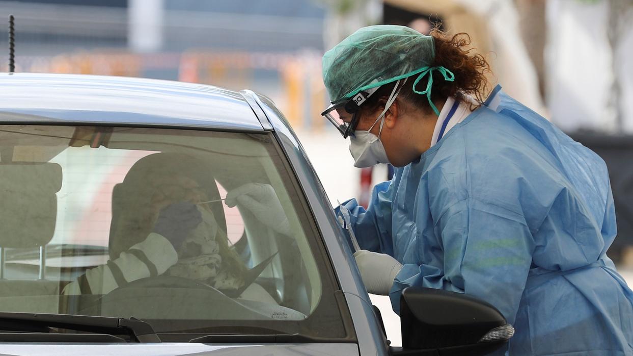 Una enfermera realiza el test rápido a una ciudadana en su vehículo.