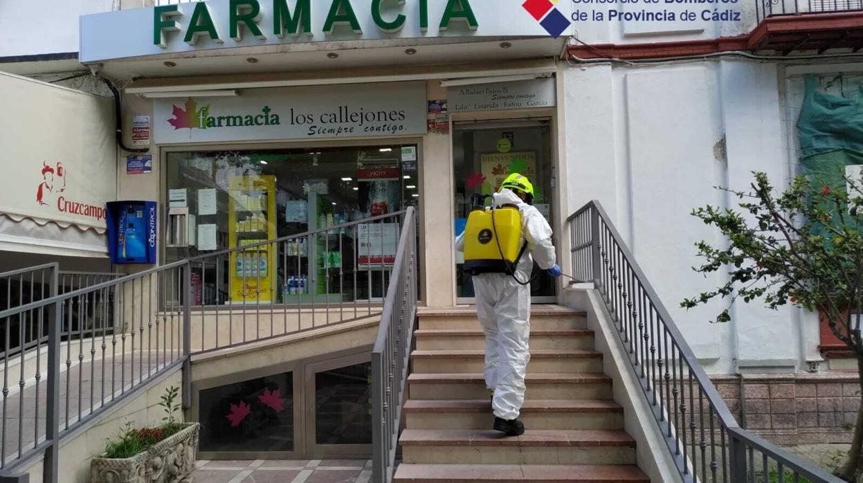 Bombeeros desinfectando una farmacia.