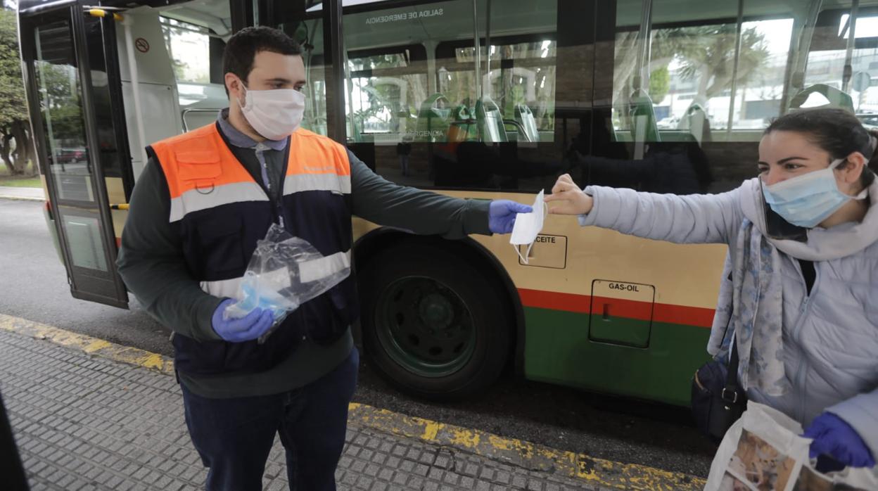 Un voluntario de Protección Civil entregando una mascarilla.