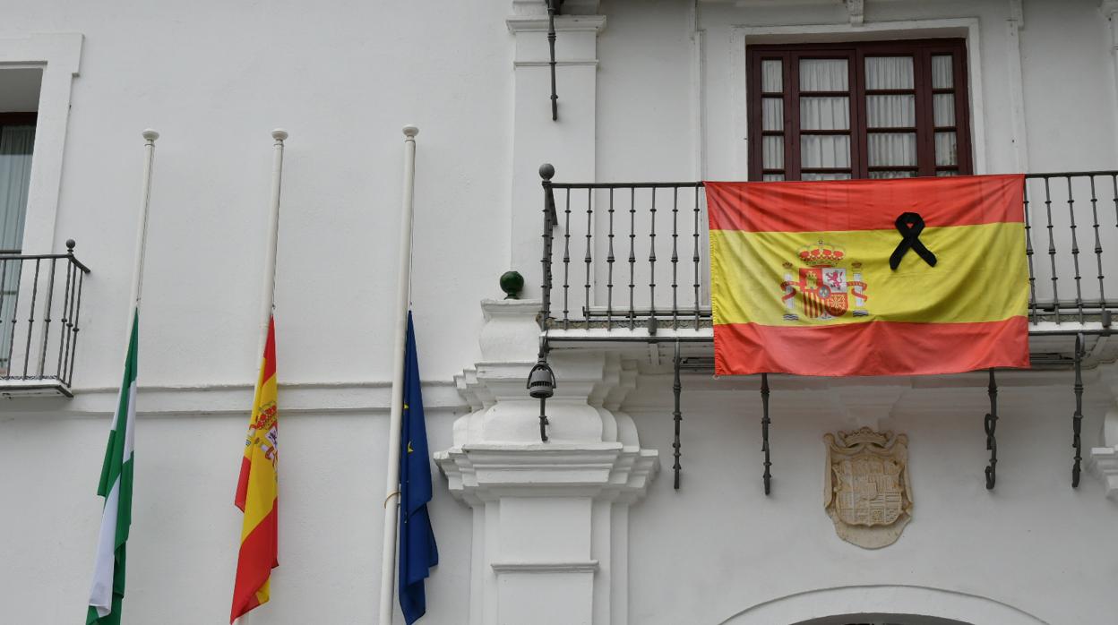 Balcón del Ayuntamiento de Tomares con las banderas a media asta y con crespón negro