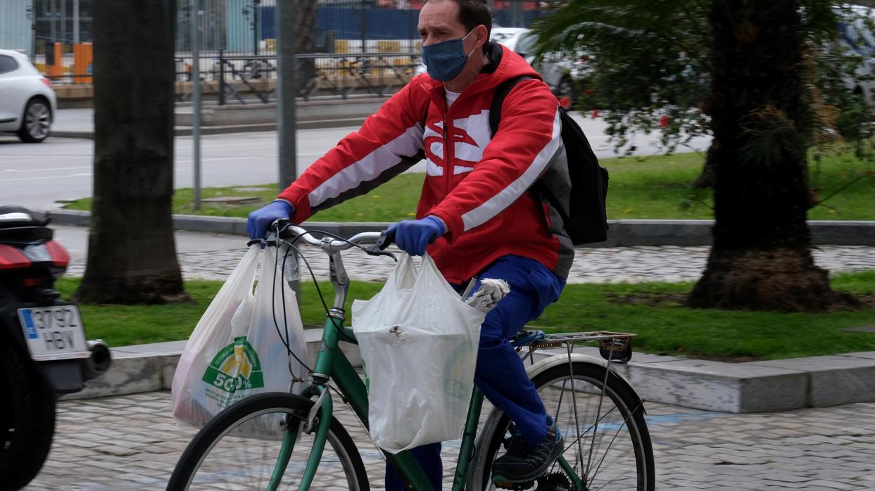 Un gaditano hace la compra en bicicleta mientras dura el confinamiento.