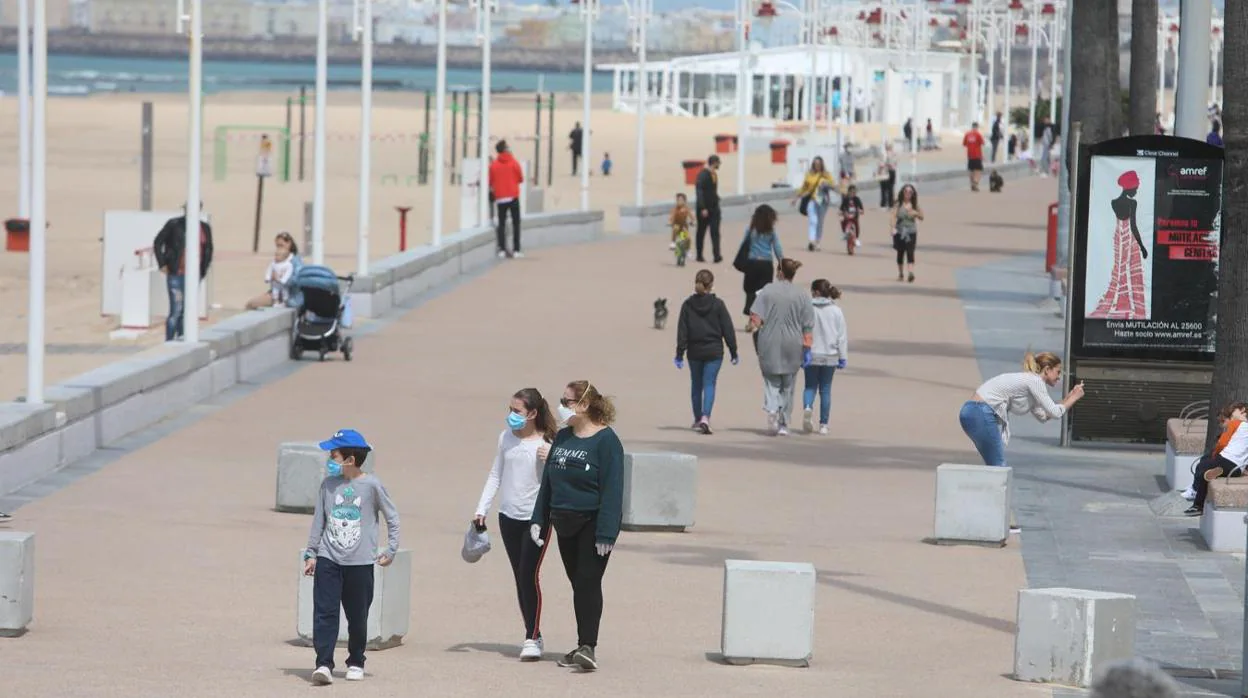 Adultos con niños paseando este domingo en Cádiz