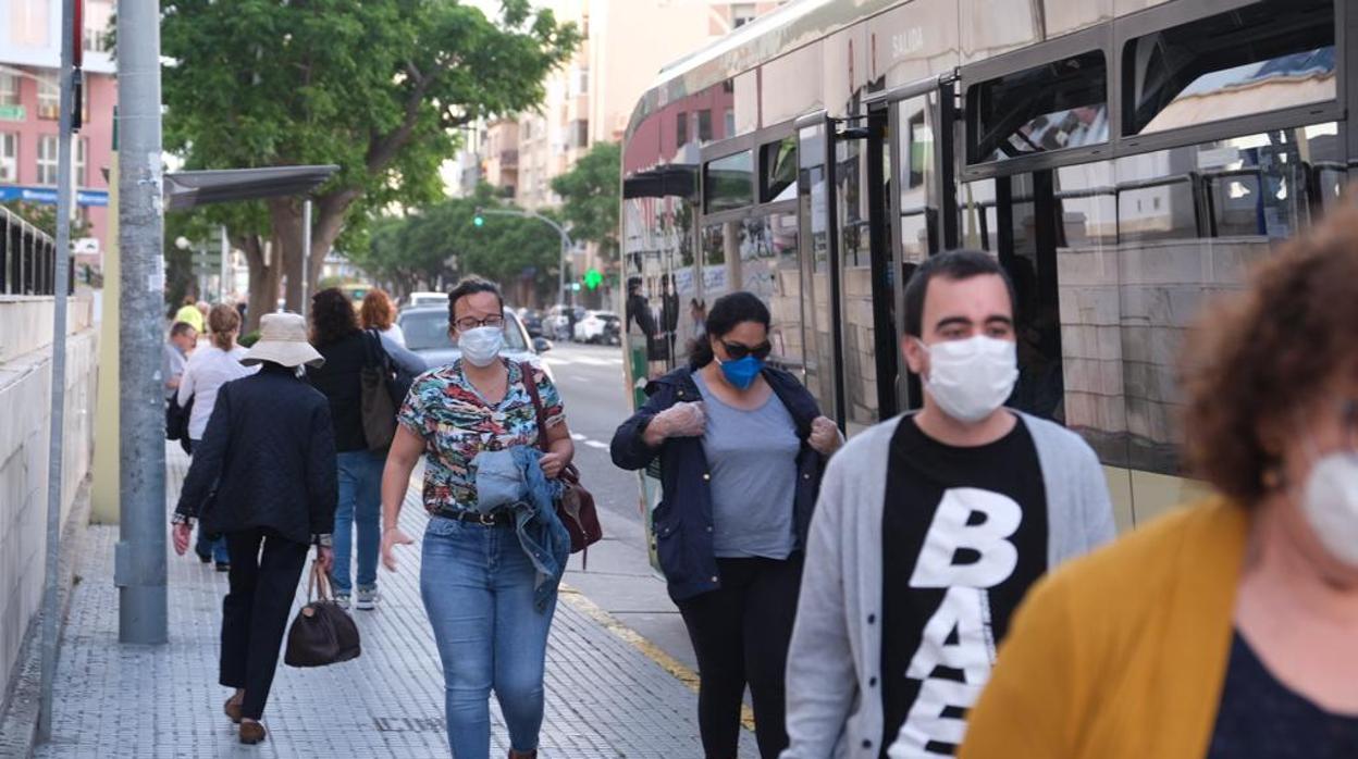 Pasajeros del transporte urbano de Cádiz con las mascarillas obligatorias.