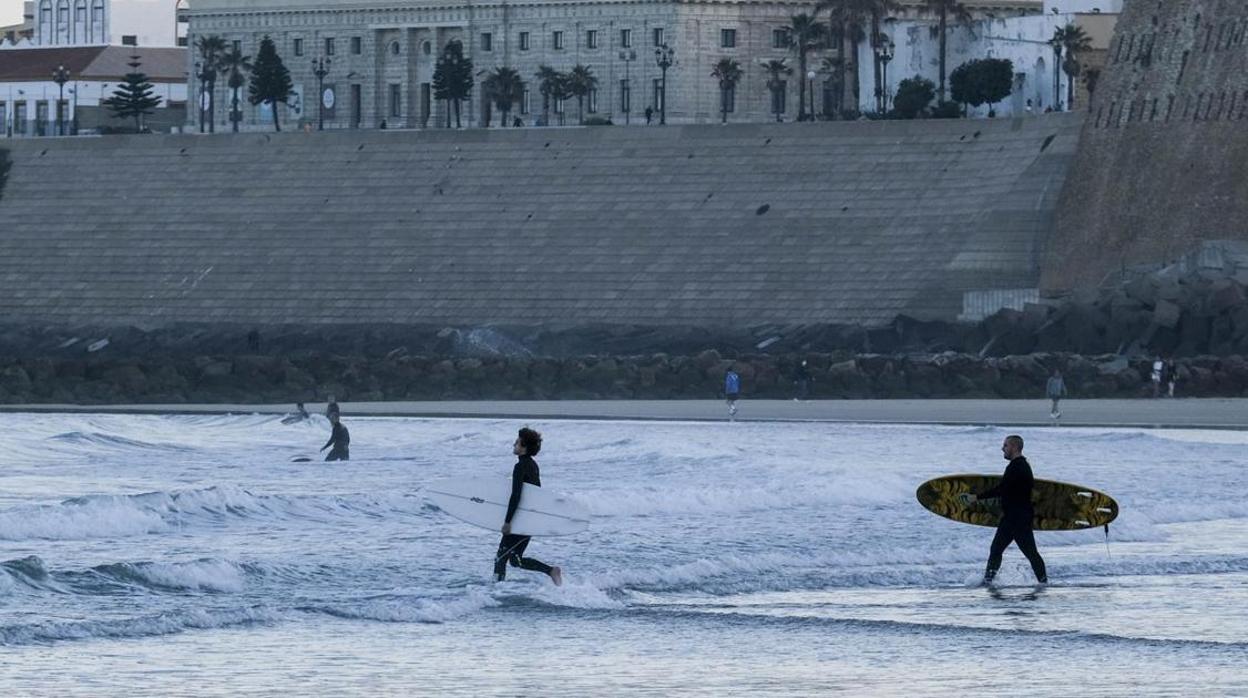 Varios surfistas en la playa de Santa María del Mar de Cádiz durante la crisis del coronavirus.