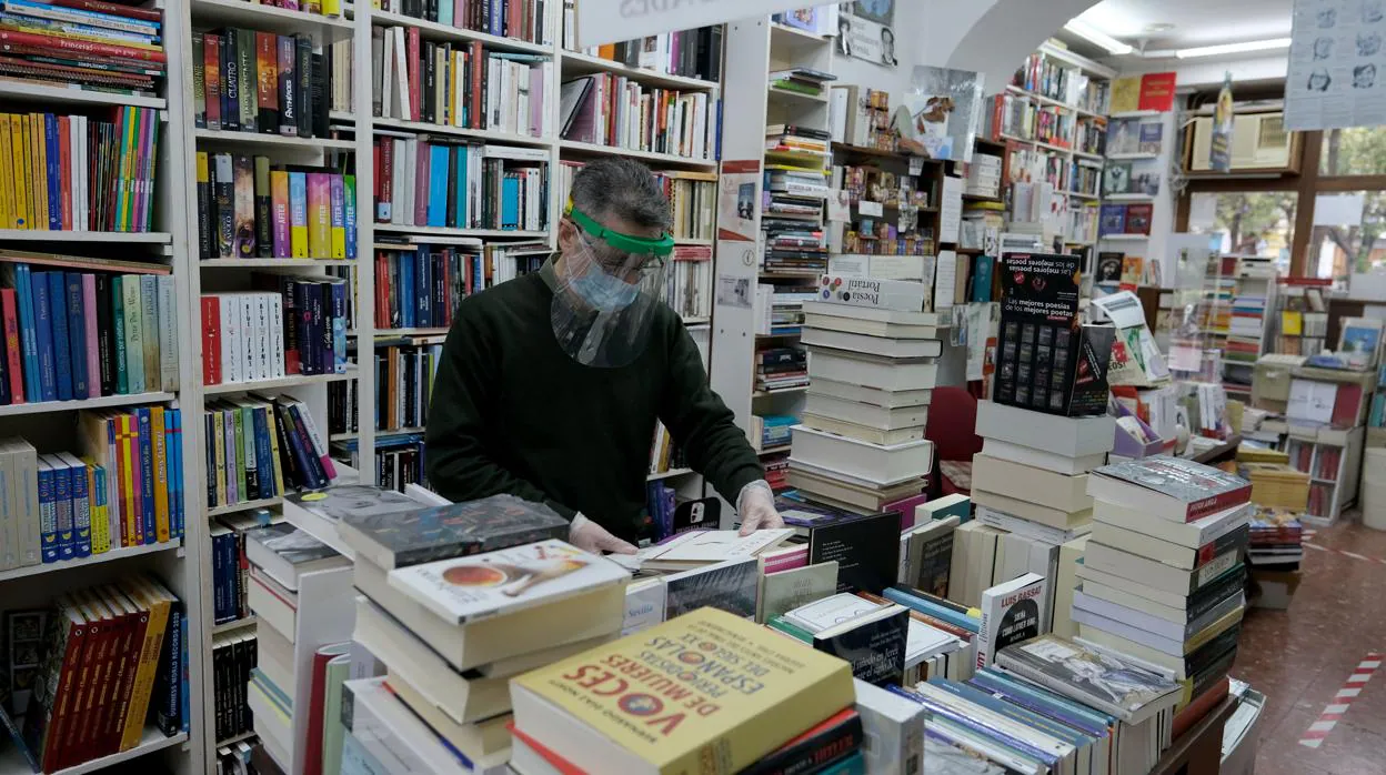 Un librero de la librería Manuel de Falla de Cádiz coloca cuidadosamente los libros