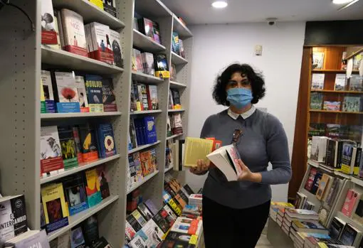 Una trabajadora de Quorum Libros organiza la estantería.