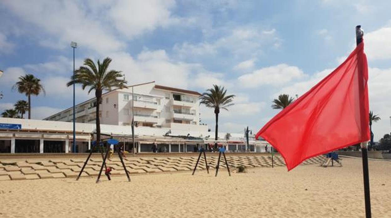 Bandera roja ondeando en una playa de Chiclana