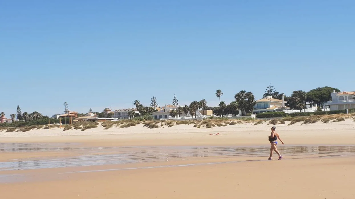 Una usuaria paseando por la playa chiclanera de la Barrosa.