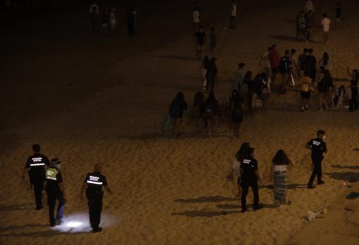 La Policía Local desaloja la playa de Santa María del Mar.
