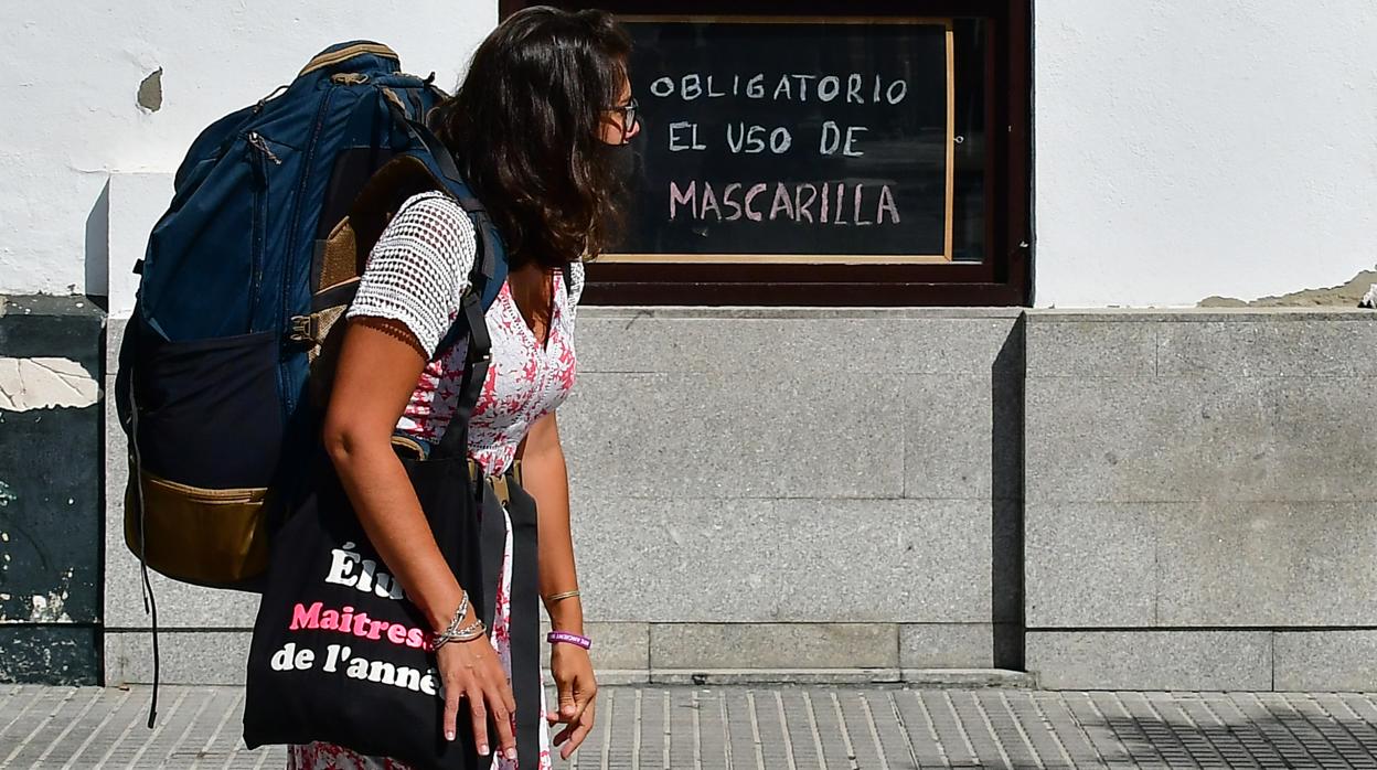 Una turista avanza por Cádiz con mascarilla.