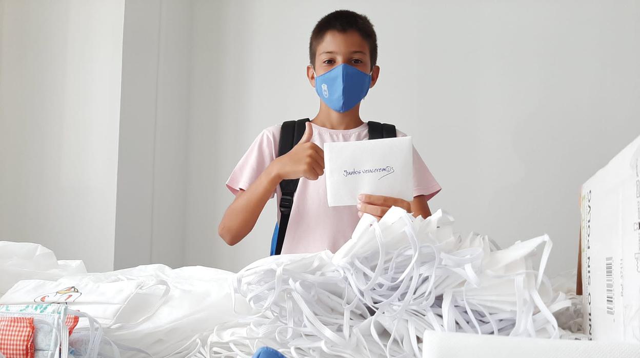 Un estudiante de Carmona con una de las mascarillas que va a repartir el Ayuntamiento a todos los alumnos