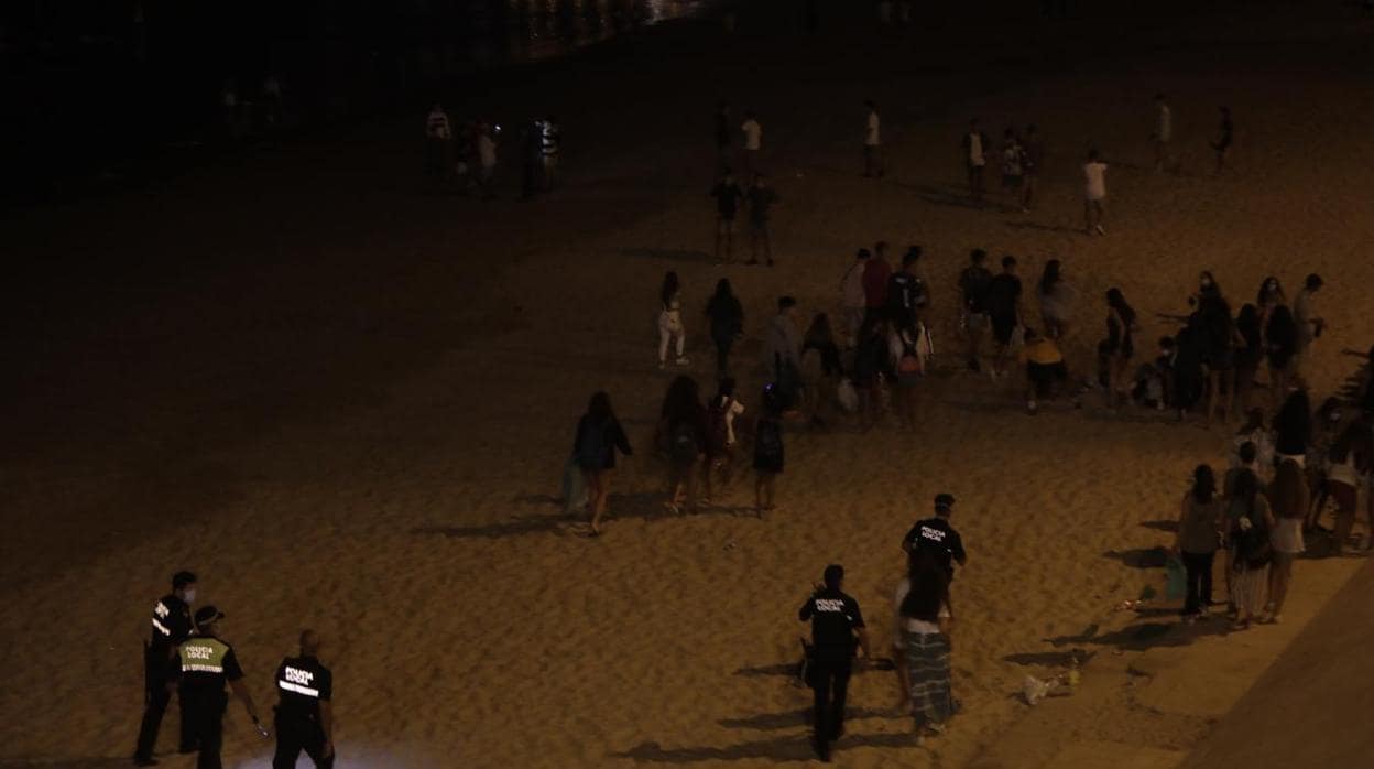 Policía Local desalojando la playa de Santa María del Mar la noche de San Juan.