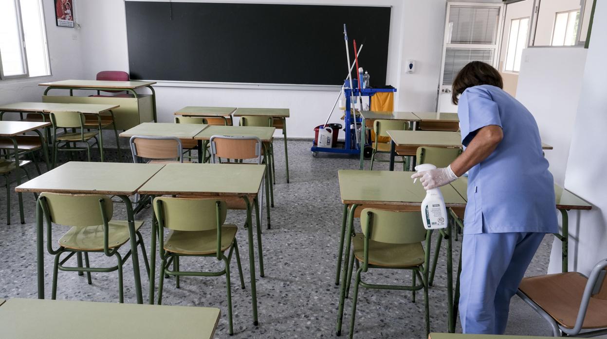 Una limpiadora desinfecta una clase en un colegio de Cádiz.