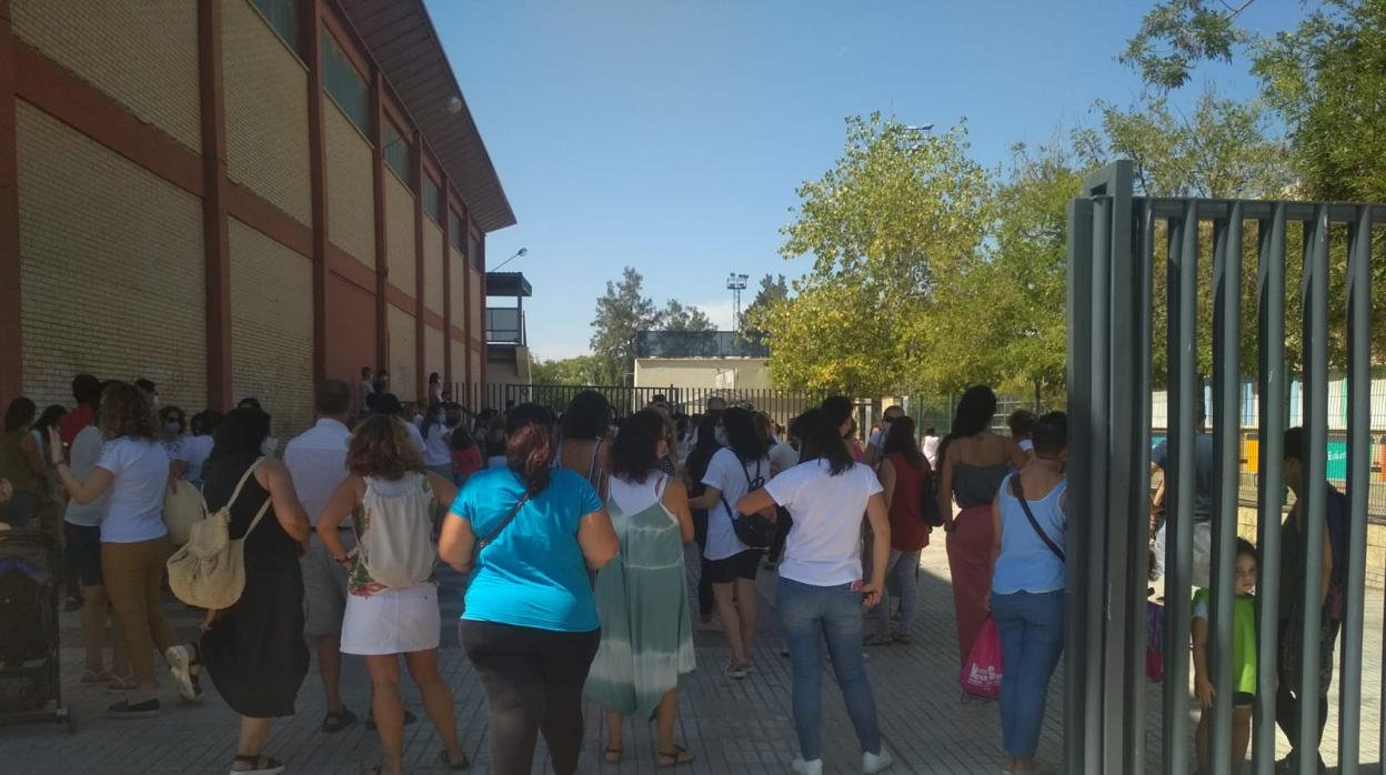 Padres y madres observan a sus hijos entrando en el primer día de cole en el CEIP Juan Caraballo