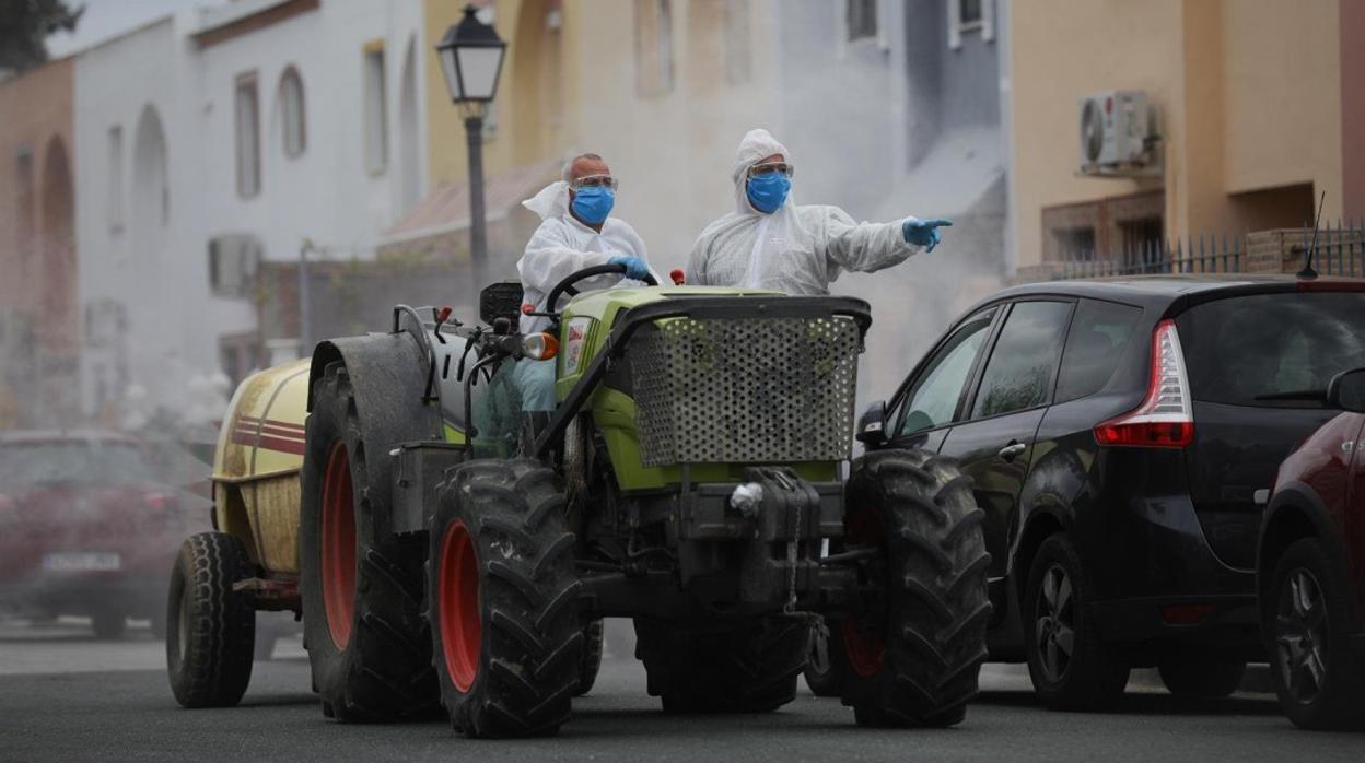 Dos personas en un tractor desinfectan las calles de La Algaba, la pasada primavera