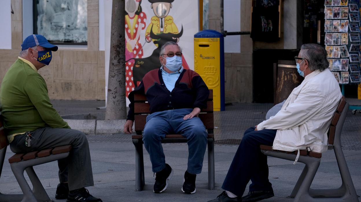 Tres mayores conversan en la plaza del Palillero, en Cádiz, entre las capitales de provincia con menos incidencia de España.