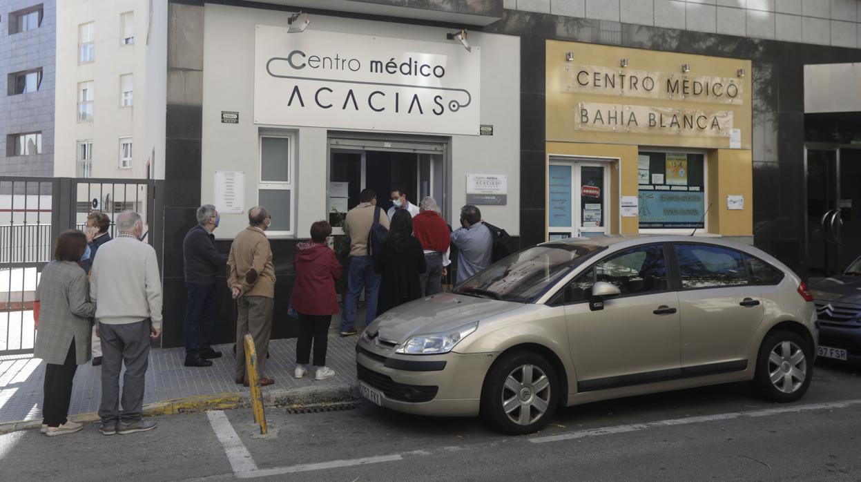 Gaditanos hacen cola para ponerse la vacuna de la gripe en un centro privado.