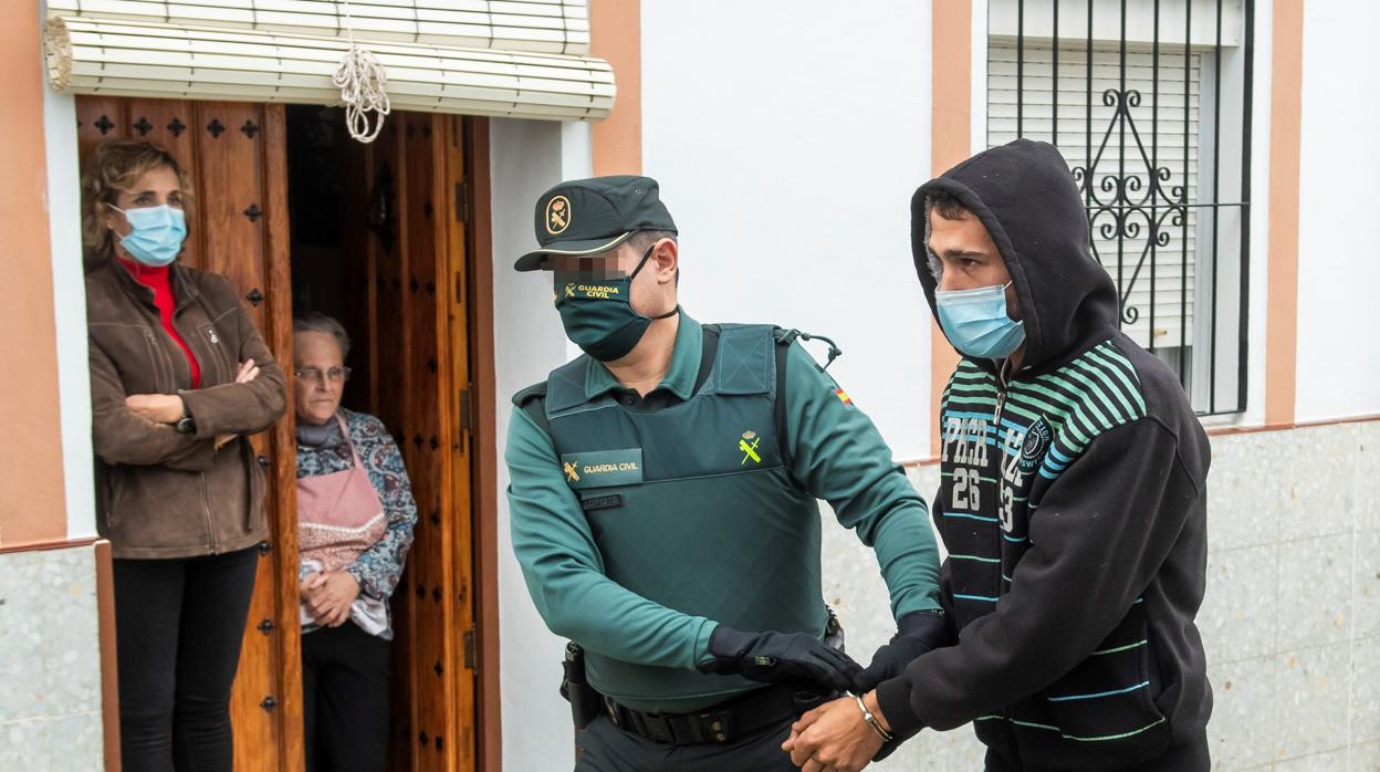 Un agente de la Guardia Civil conduce al «Varita» a dependencias policiales en Castilblanco