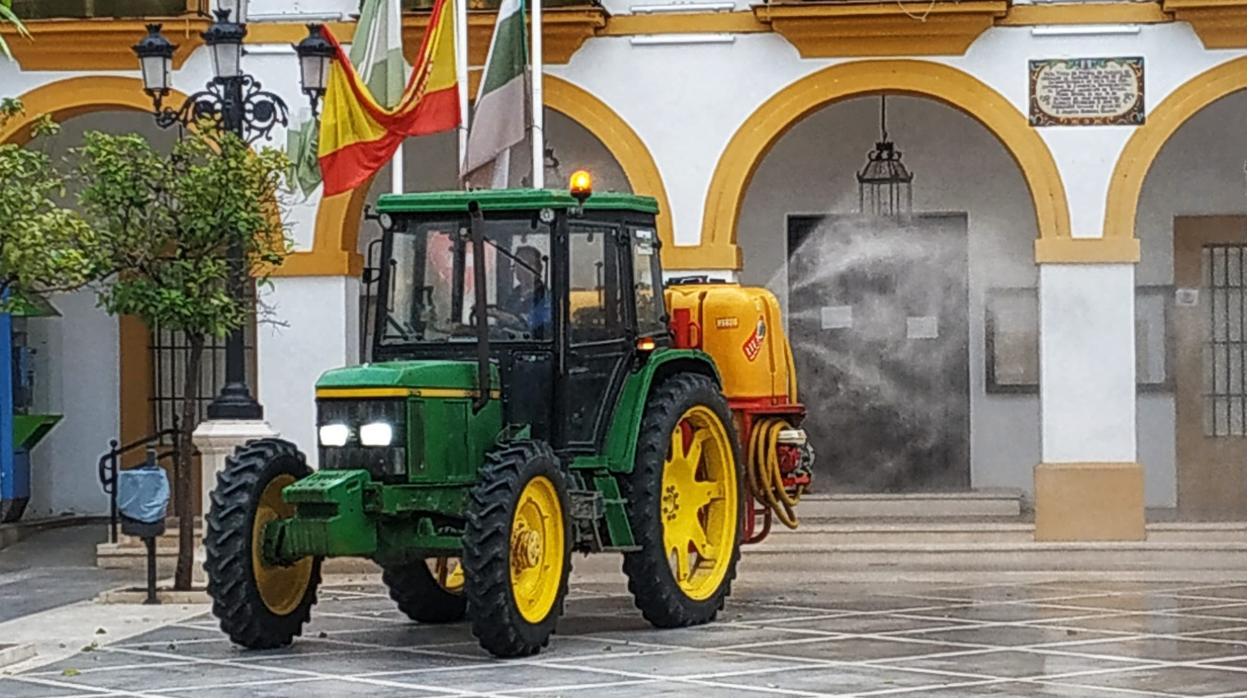 Un tractor desinfecta la plaza del Ayuntamiento de La Puebla de Cazalla